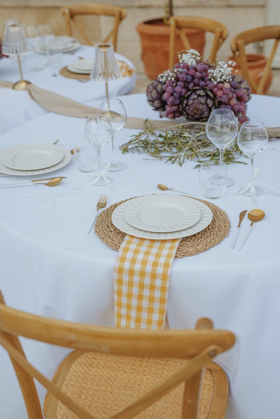 Table ronde nappée blanc avec set en jonc et vichy jaune